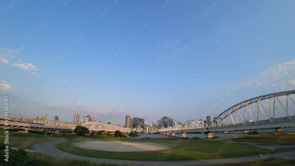 OSAKA, JAPAN - JUNE 2024 : View of buildings around Osaka station, bridge and Yodogawa river. Time lapse shot in sunset time. OSAKA, JAPAN - JUNE 2024 : View of buildings around Osaka station, bridge and Yodogawa river. Time lapse shot in sunset time.