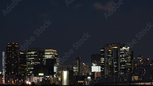 OSAKA, JAPAN - JUNE 2024 : View of buildings around Osaka station, bridge and Yodogawa river. Time lapse shot at night. photo