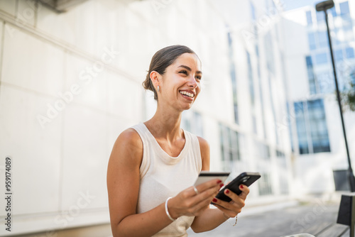 Young woman sit outdoor and buy online on cellphone with credit card