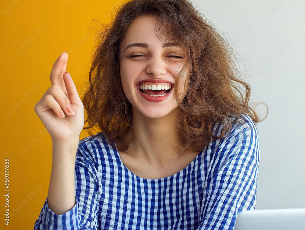 Fototapeta premium Happy young women working in the office, sitting with a chair and enjoying success, looking at the laptop screen and showing a victory gesture with her hand