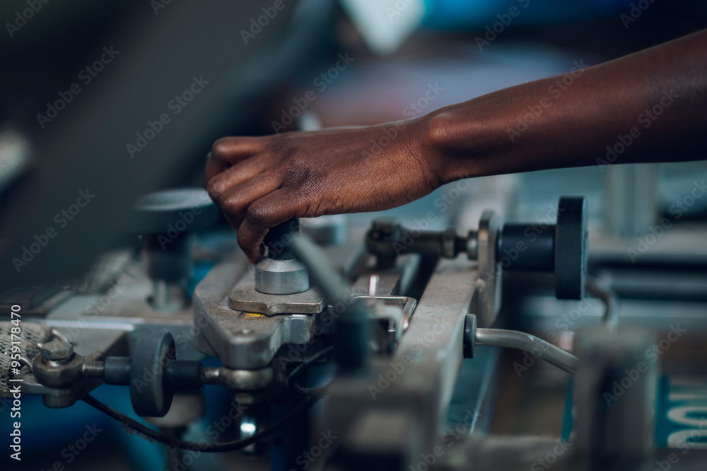 Close up of diverse graphic worker's hand adjusting printing machine. Close up of diverse graphic worker's hand adjusting printing machine.