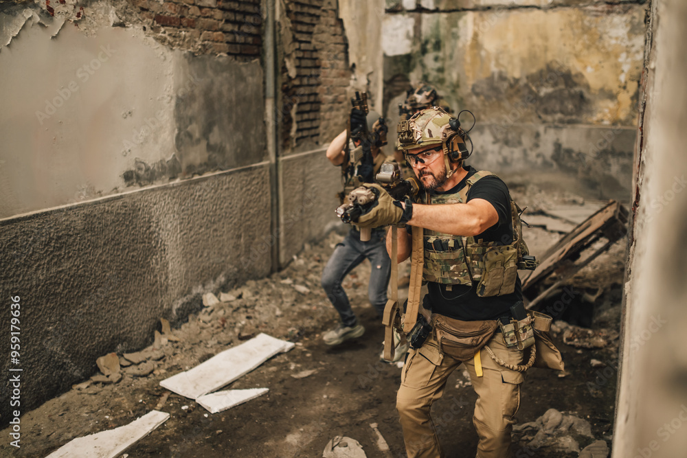 Fototapeta premium Troops waking towards camera in ruins with weapon and going in battle.