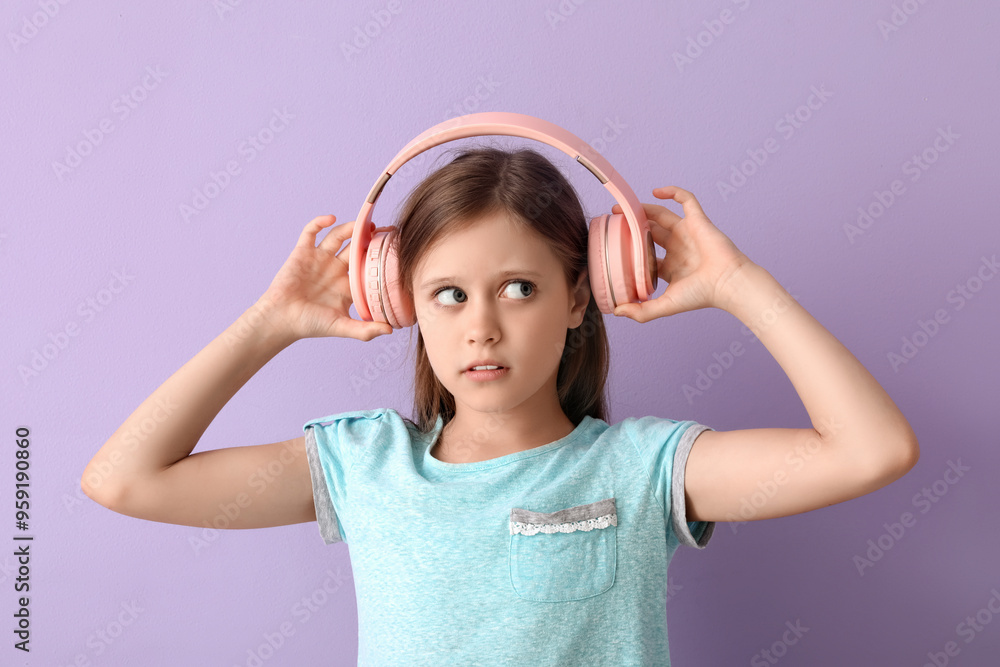 Little girl in headphones on lilac background Little girl in headphones on lilac background