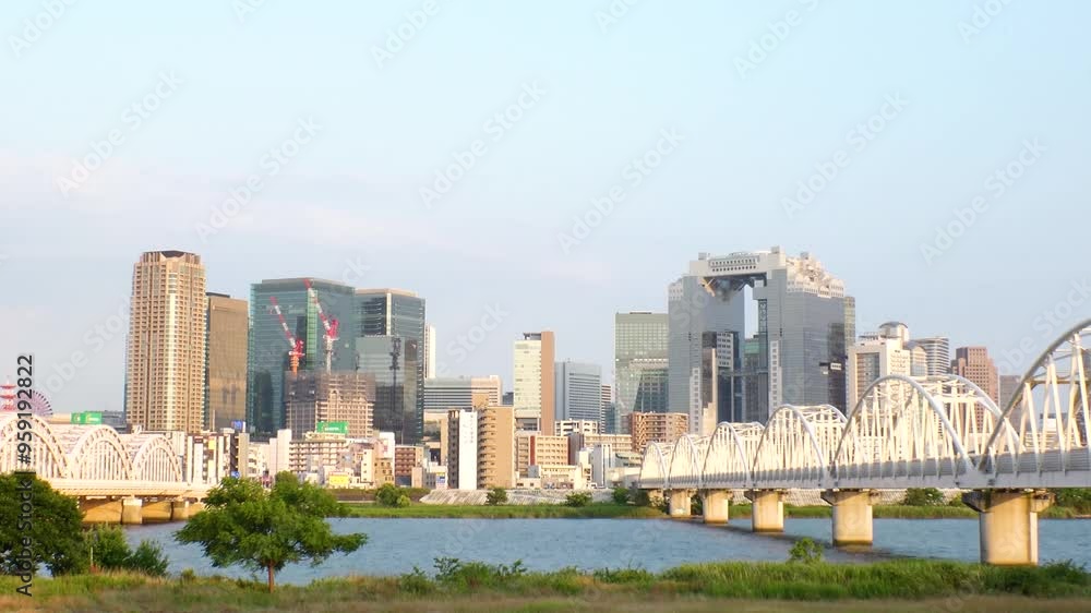 OSAKA, JAPAN - JUNE 2024 : View of buildings around Osaka station, bridge and Yodogawa river. Time lapse shot, sunset to night. OSAKA, JAPAN - JUNE 2024 : View of buildings around Osaka station, bridge and Yodogawa river. Time lapse shot, sunset to night.