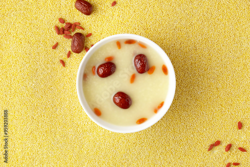 Close-up of porridge of red dates and wolfberries, millets background, top view