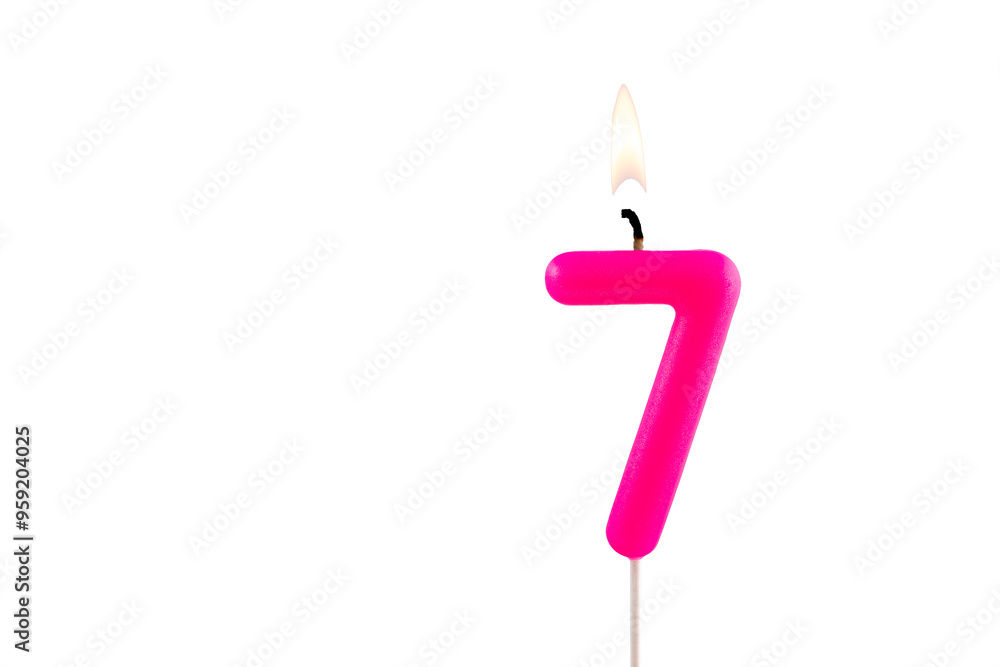 Pink number 7 birthday candle lit on white background Pink number 7 birthday candle lit on white background