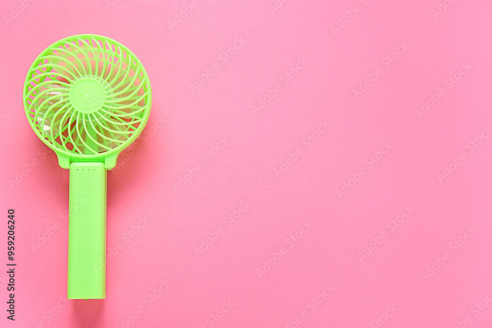 Modern manual fan on pink background Modern manual fan on pink background