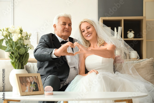 Mature couple making heart ...