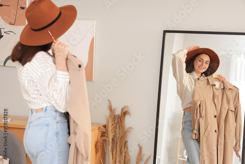 Young woman trying on trenc...