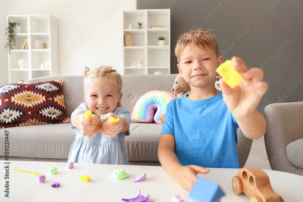 Cute little children sculpting from plasticine at table Cute little children sculpting from plasticine at table