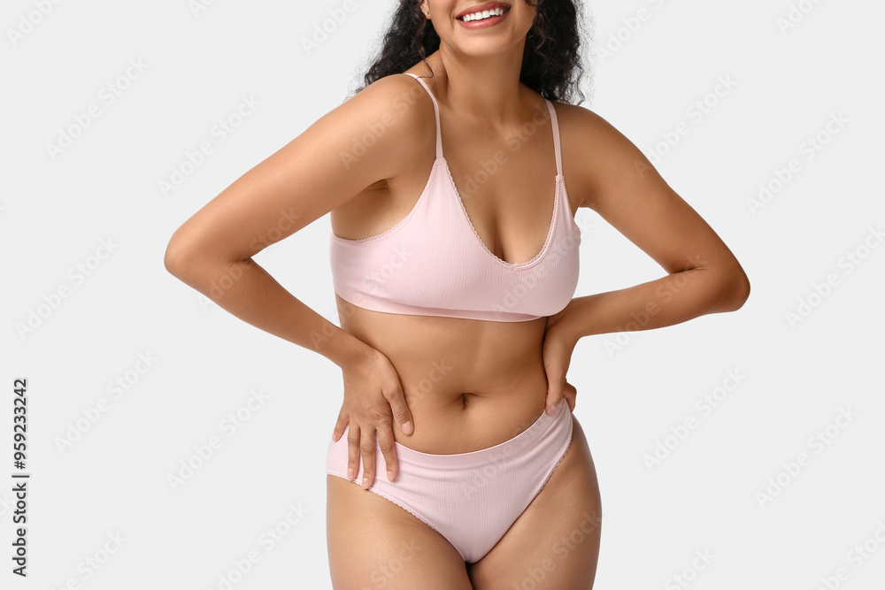 Beautiful young happy African-American body positive woman on grey background, closeup Beautiful young happy African-American body positive woman on grey background, closeup