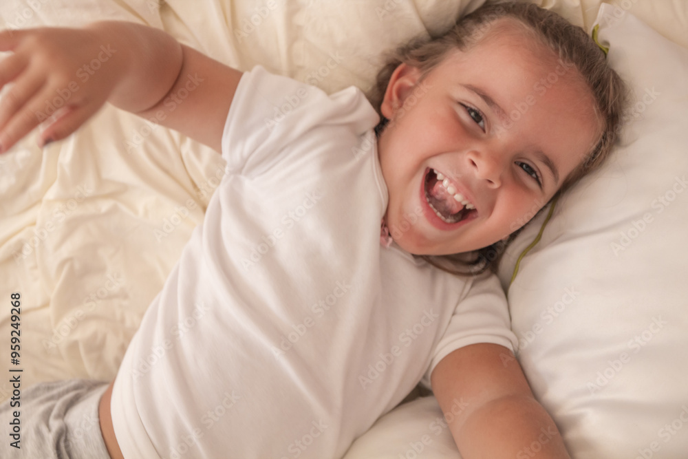 the little girl playing and tickling on the bed and having fun the little girl playing and tickling on the bed and having fun