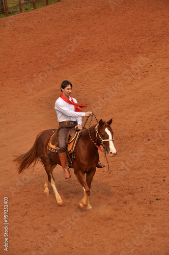 homem gaúcho com lenço vermelho tradicional cavalgando em fazenda 