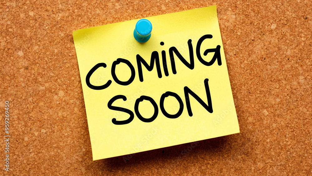 coming soon word written on a note sticky on corkboard