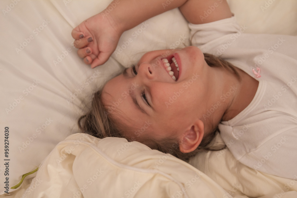 the little girl playing and tickling on the bed and having fun the little girl playing and tickling on the bed and having fun