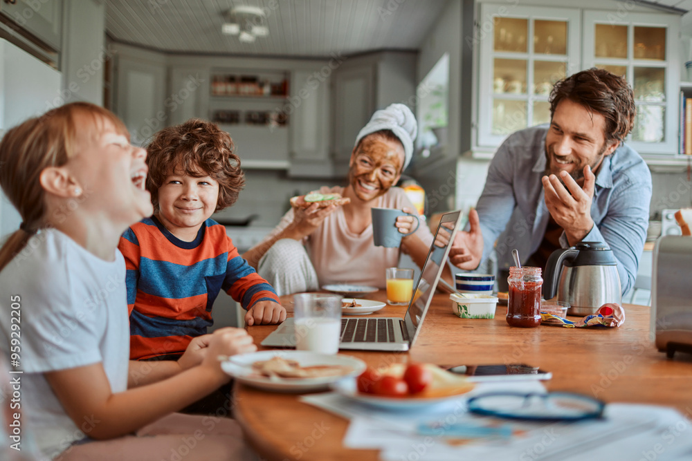 Happy family enjoying breakfast together in modern kitchen with laptop Happy family enjoying breakfast together in modern kitchen with laptop