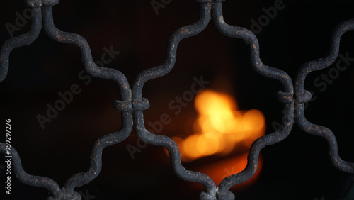 Old black iron trellis. Focus selected. Blurred fire background