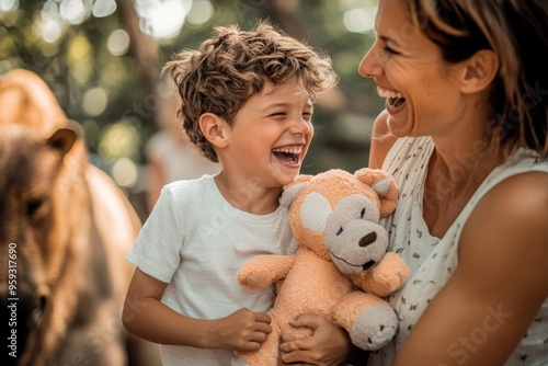 High-resolution brightly lit photorealistic candid photograph of a family laughing together at the zoo, with the son holding a stuffed animal, and a soft, creamy bokeh background. The photograph is photo