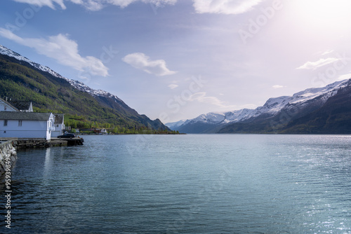 A peaceful village nestled on the coast of the Hardangerfjord. The contrast between the white houses and the calm turquoise waters is striking. Voss, Norway.