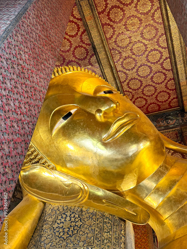 The famous Reclining Buddha statue in Wat Pho Temple, Bangkok, Thailand. Reclining Buddha inside Wat Pho made of gold materials. photo