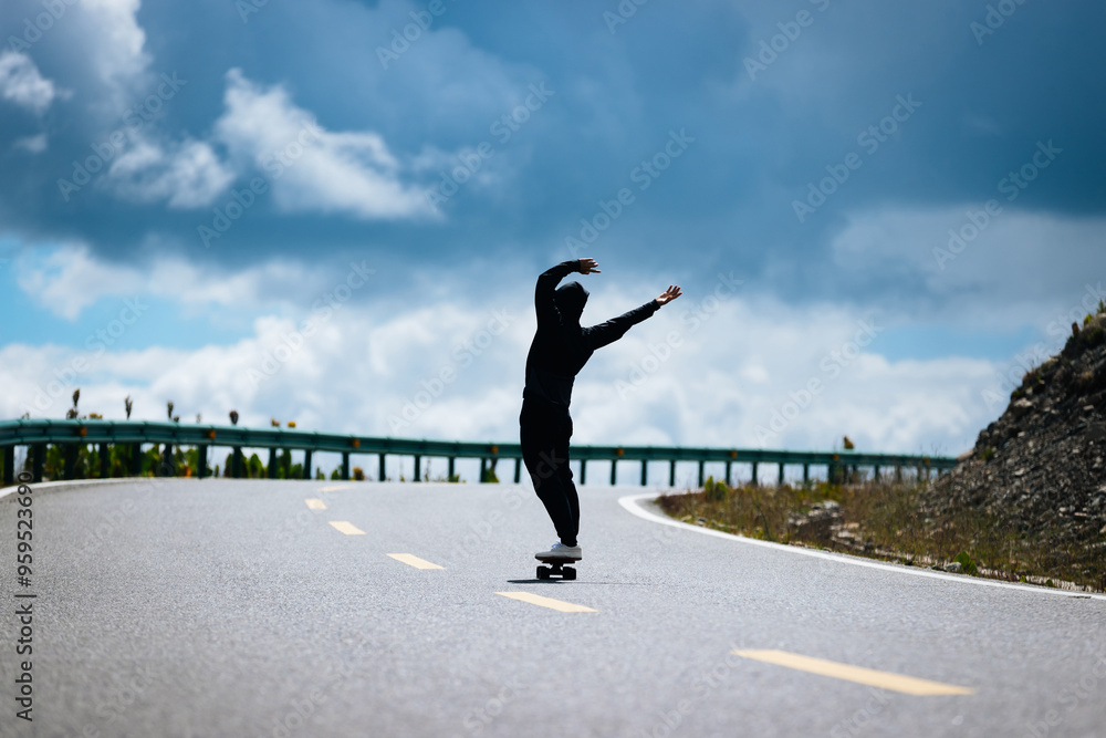 Skateboarder with back pain while skateboarding on the mountain road Skateboarder with back pain while skateboarding on the mountain road
