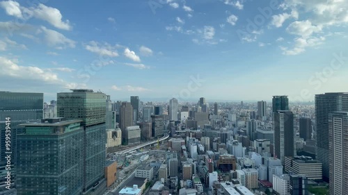 UMEDA, OSAKA, JAPAN - JUNE 2024 : Aerial high angle view around Osaka train station in daytime. View of crowded buildings at downtown area. Urban city and business concept video. Time lapse shot.
