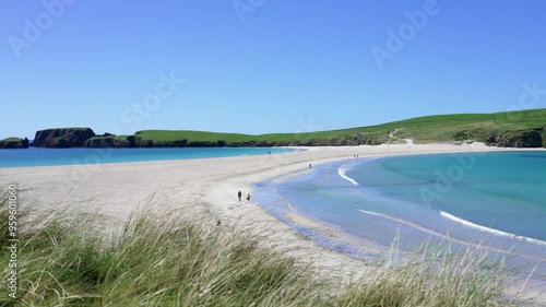 Walkers enjoying a sunny day at St Ninian's Beach, Shetland , Scotland