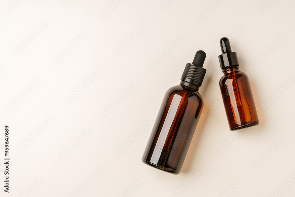 Naklejka premium Various Amber Glass Containers for Essential Oils and Skin Care Products Displayed on Light Background