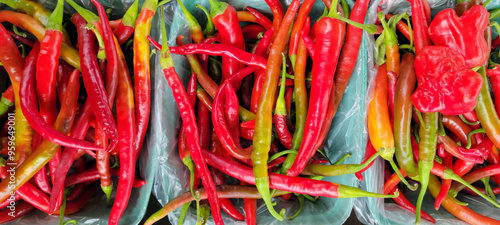 Colorful chili peppers displayed in baskets at a market stall photo