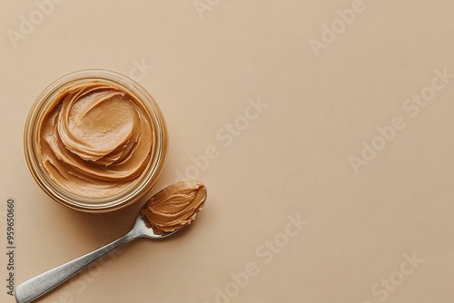 Jar and spoon of peanut butter on beige background. Top view. Generative Ai