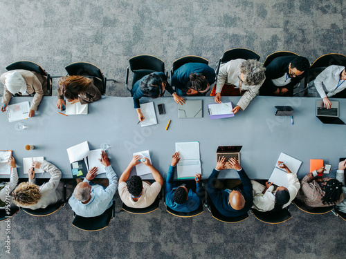 Photography Overhead shot of business panel in office meeting collaborating around large tab