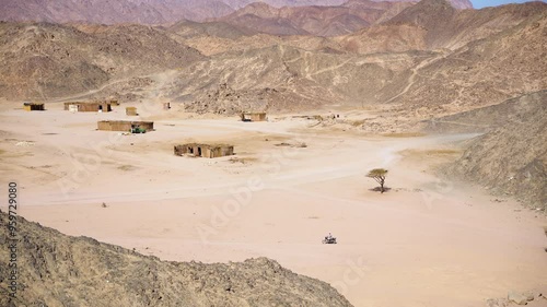 A motorcycle passes through a Bedouin village in the desert between the mountains, Egypt