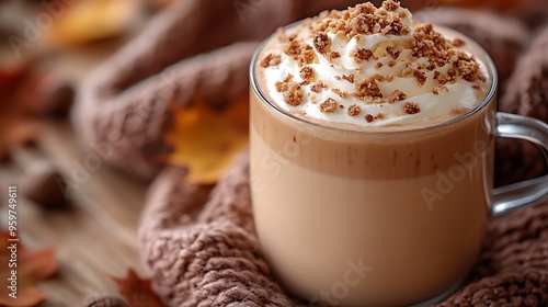 A beautifully crafted chestnut praline latte with whipped cream and a generous sprinkle of praline crumbs, placed on a wooden table with a cozy scarf draped beside it, scattered autumn leaves,