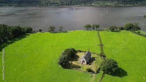 The legendary St Bega’s Church, Bassenthwaite, Lake District, UK, full of folklore - Aerial drone anti-clockwise rotate and move in then out from high photo