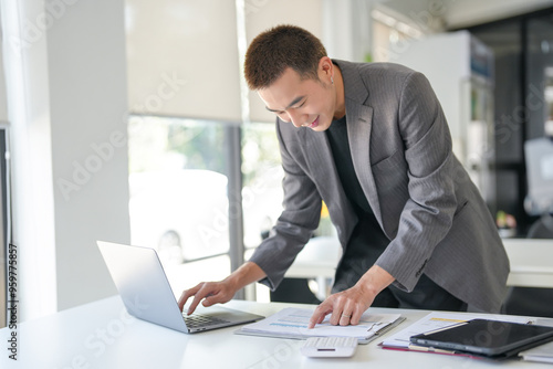 Young business man busy standing work at office. businessman using computer laptop business management