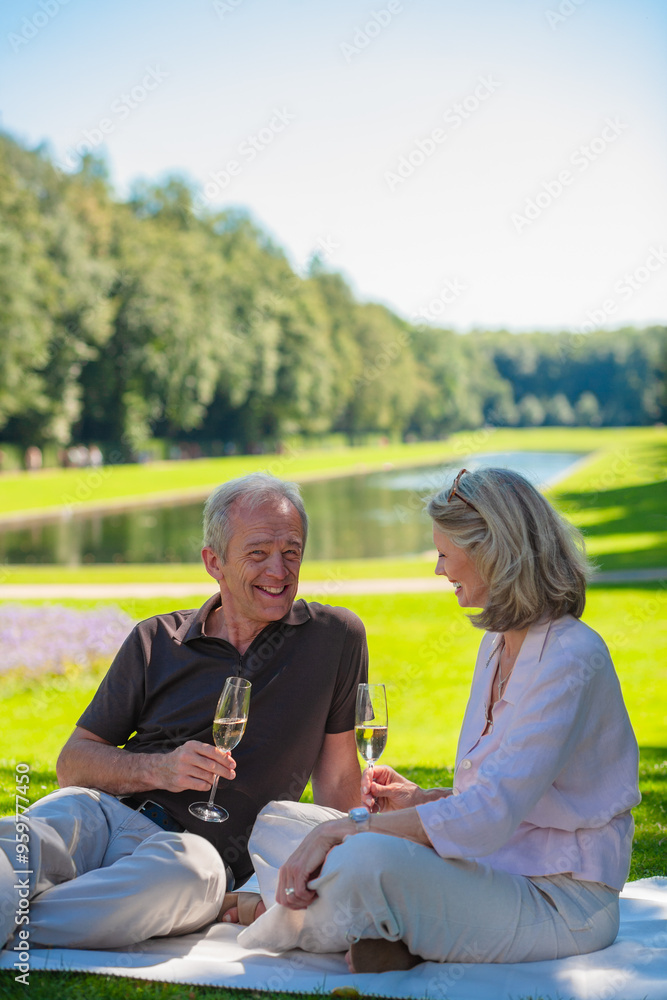 Ein älteres Pärchen trinkt Sekt in einem Park, KI generiert Ein älteres Pärchen trinkt Sekt in einem Park, KI generiert