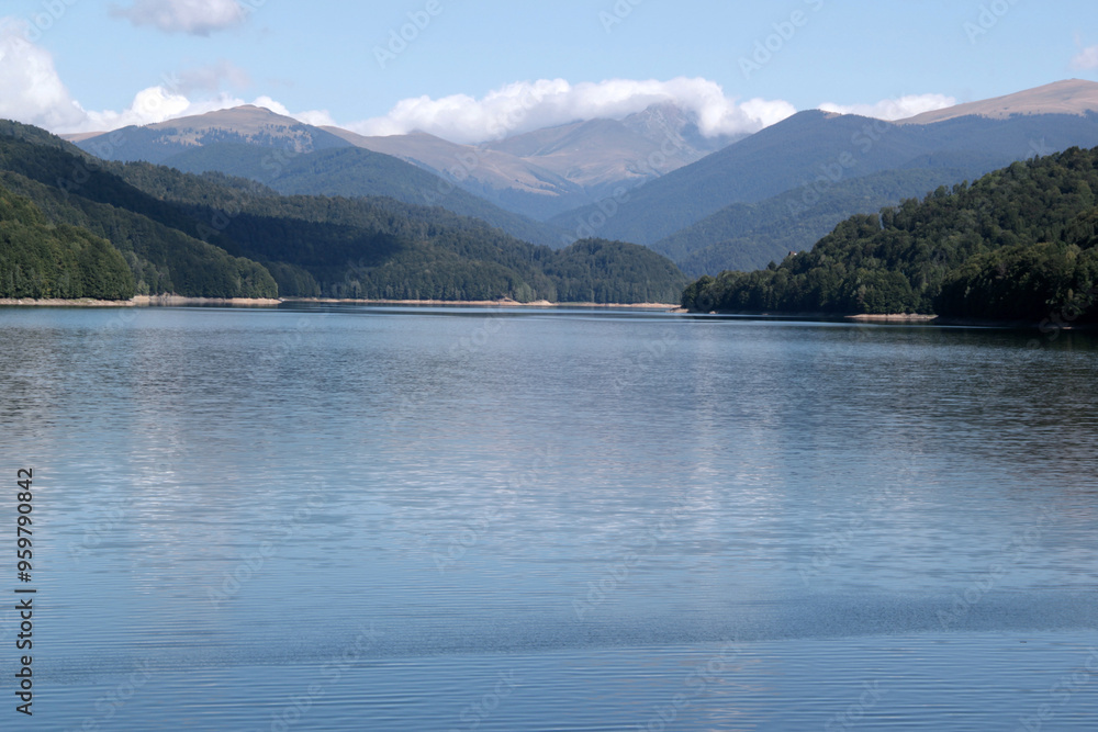 Landscape photo with a view of the mountains and the smooth mirror surface of Lake Vidraru against a blue sky with clouds in Romania
Landscape photo with a view of the mountains and the smooth mirror surface of Lake Vidraru against a blue sky with clouds in Romania
