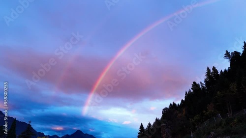 Magnificent double rainbow in dusking sky above forest and mountains next to Walter Peak in Queenstown photo