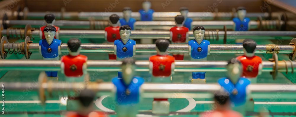 Obraz premium Retro table soccer with wooden miniature figurines of players on metal bars, mini soccer table game. table football soccer game.