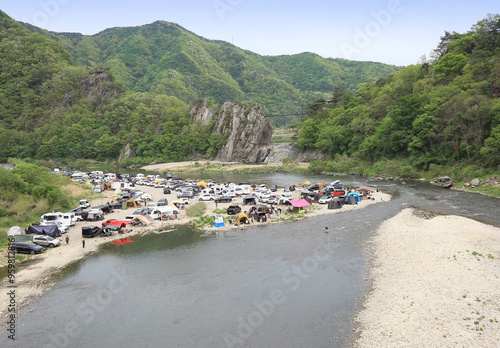 Chungju-si, Chungcheongbuk-do, South Korea - April 24, 2021: High angle view of tourists and cars for camping at Sujupalbong Recreation Area near Dalcheon River photo