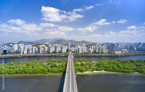 Mapo-gu, Seoul, South Korea - April 18, 2021: Aerial view of Sogang Bridge and Bamseom Island on Han River with Gangbyeon Expressway and high-rise buildings in the background photo