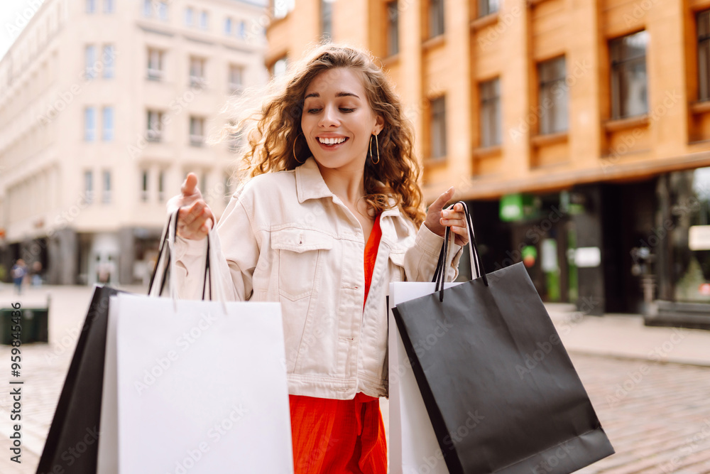 A young woman enjoys a sunny day shopping with multiple bags in a vibrant urban street filled with shops and cafes. Consumerism, sale, purchases, shopping, lifestyle concept. A young woman enjoys a sunny day shopping with multiple bags in a vibrant urban street filled with shops and cafes. Consumerism, sale, purchases, shopping, lifestyle concept.