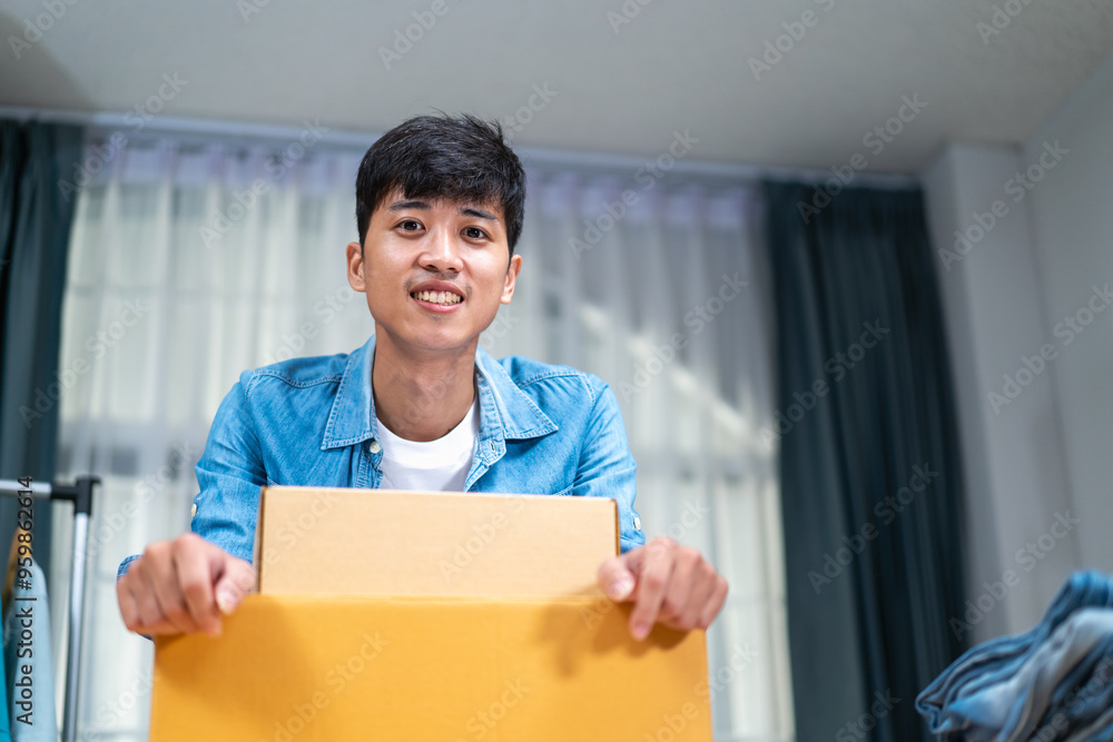 Young Asian man, distributor, online shop owner, small business owner, standing in warehouse and preparing to ship goods, with parcel boxes. Young Asian man, distributor, online shop owner, small business owner, standing in warehouse and preparing to ship goods, with parcel boxes.