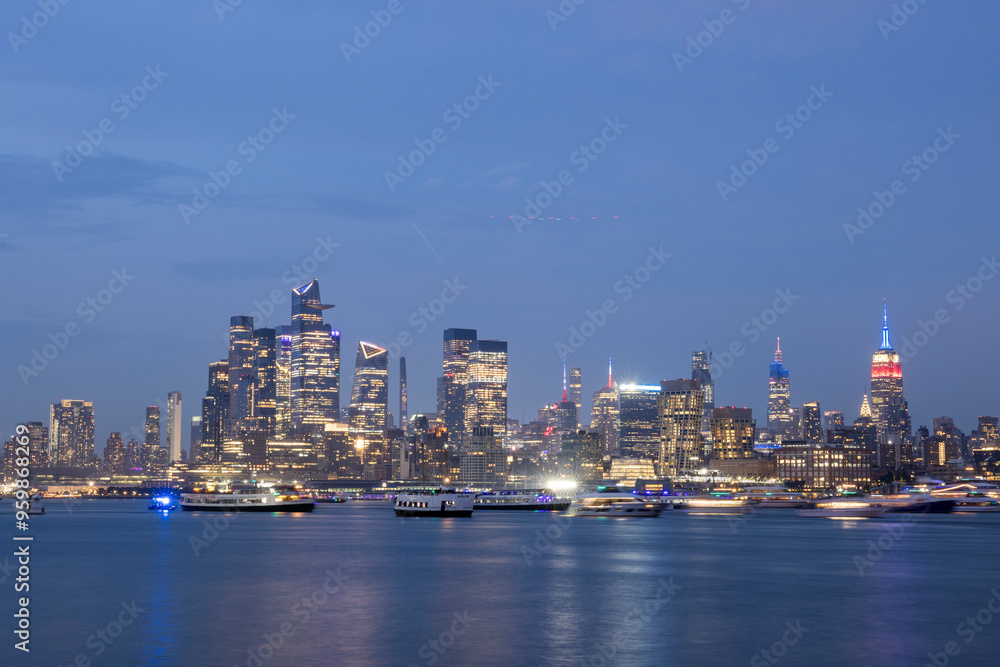 View of illuminated skyline and skyscrapers reflecting on the Hudson River at night, New York City, United States. View of illuminated skyline and skyscrapers reflecting on the Hudson River at night, New York City, United States.