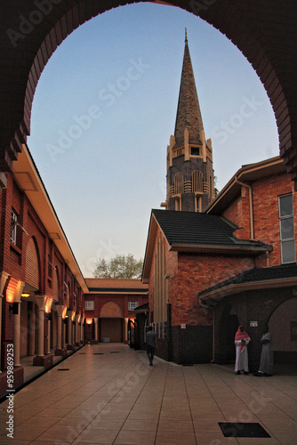View of historic church with spire and archway during twilight, Pretoria, South Africa.