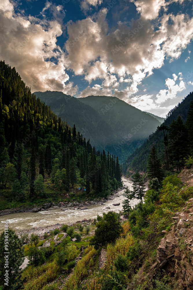View of breathtaking mountain and verdant valley with winding river and lush forest under a dramatic cloudscape, Kashmir, Pakistan. View of breathtaking mountain and verdant valley with winding river and lush forest under a dramatic cloudscape, Kashmir, Pakistan.