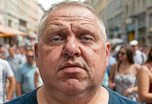 mature adult man strolling in a shopping street between buildings with shops and many people in the city, age 40-60, relaxed and motivated, good mood