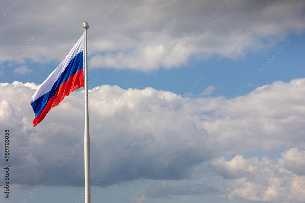 Flag of Russian Federation is flying in air on blue sky and white cumulus clouds. National flag of Russian Flag of Russian Federation is flying in air on blue sky and white cumulus clouds. National flag of Russian