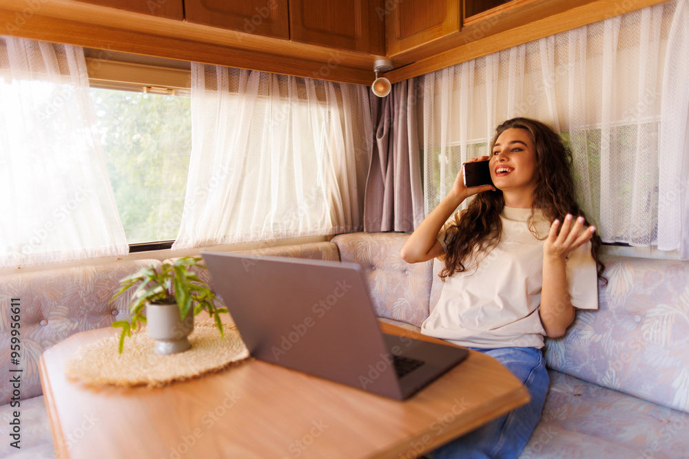 Young woman talk phone, while sit in camper at road travel Young woman talk phone, while sit in camper at road travel