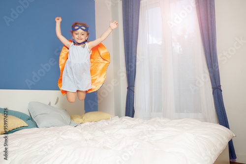 Wallpaper Mural Child girl in cape flying through air onto bed, superhero dream Torontodigital.ca